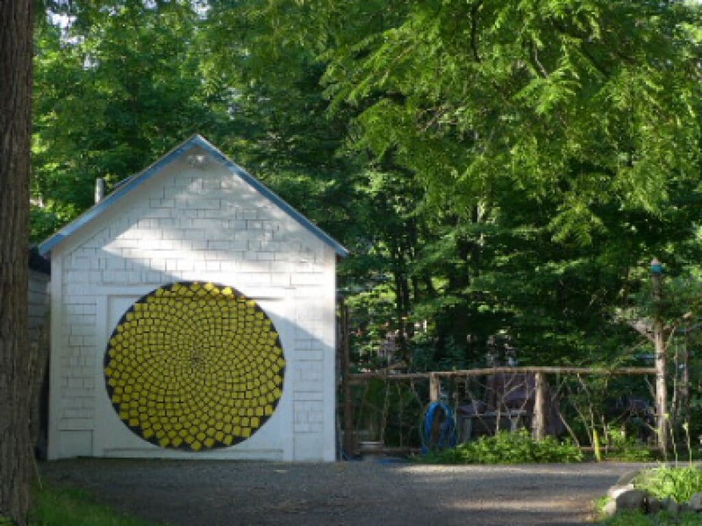 Un pequeño edificio blanco con un motivo amarillo circular en la fachada.