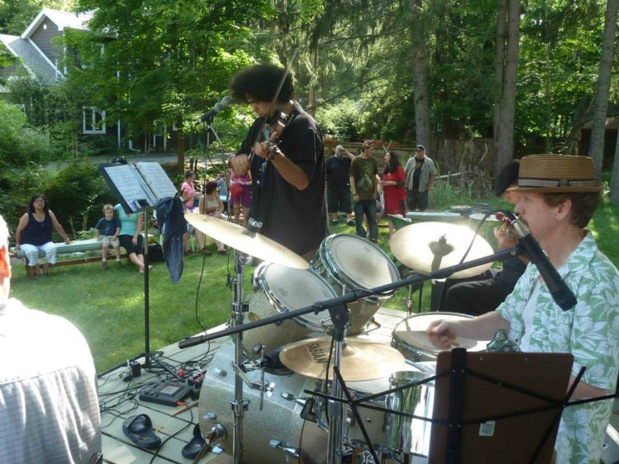 Een drumstel buiten met een notestand en bladmuziek.