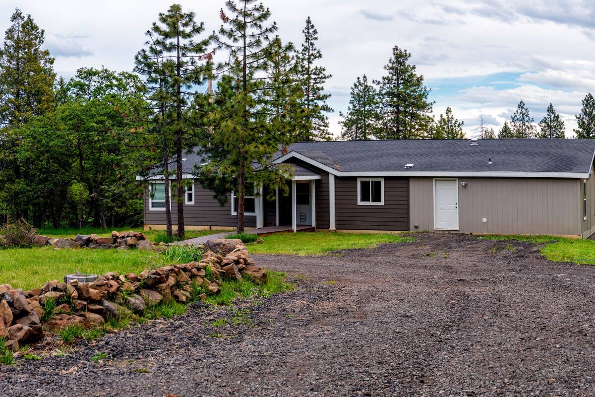 A single-story house with a grey exterior, a front porch, and a garage.