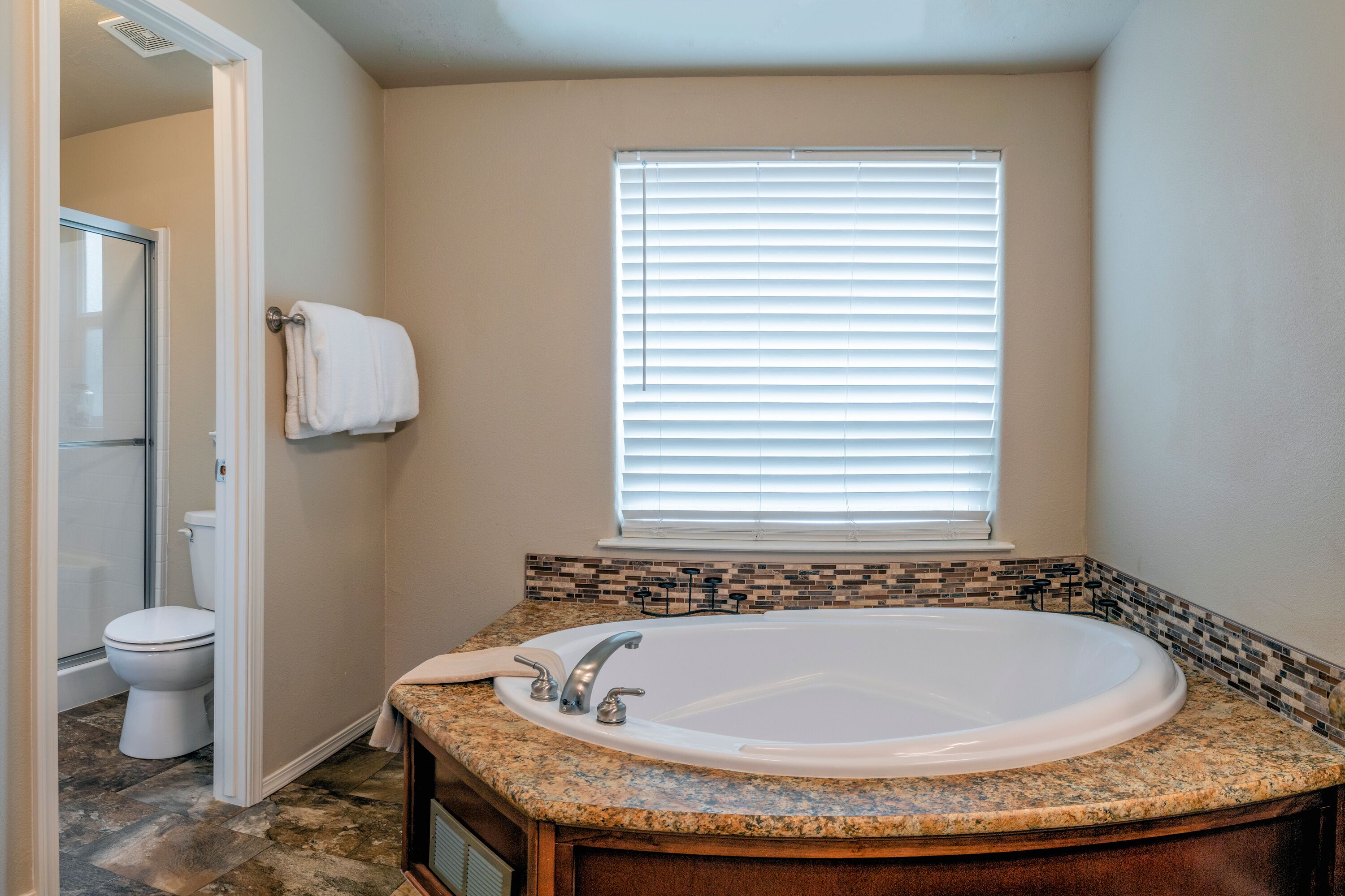 A bathroom with a large bathtub, a toilet, and a shower.