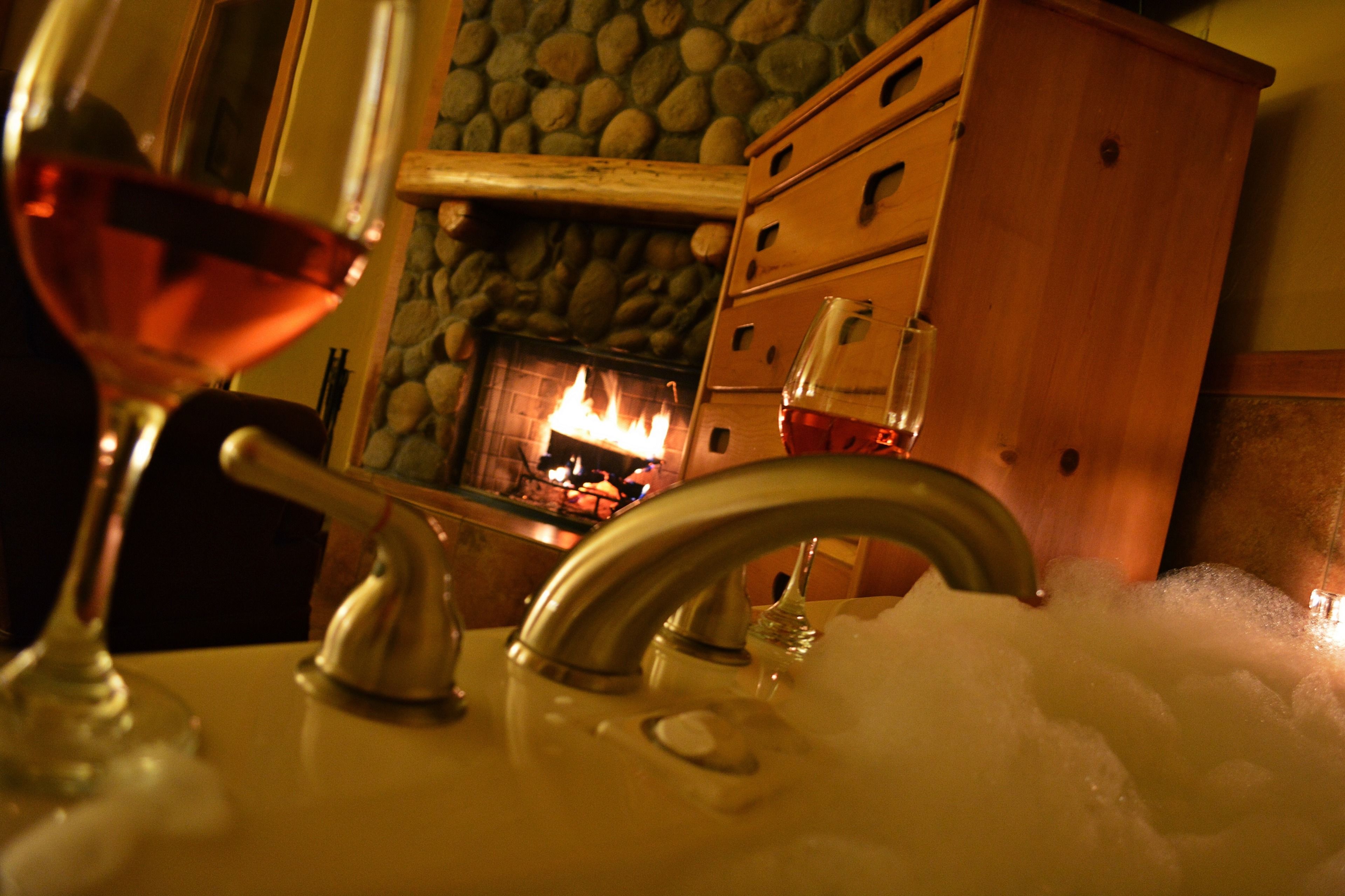 A bathroom with a sink, a mirror, and a stone wall with a fireplace.