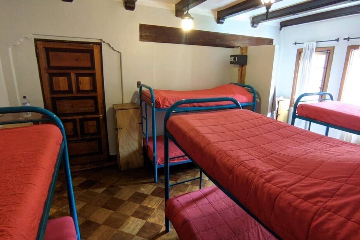 Ein Zimmer mit Etagenbetten, einer Holztür und einem Schachbrettmuster-Boden.