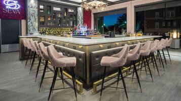 Eine moderne Bar mit einer zentralen Barinsel, Barhocker und einem Neonlicht.