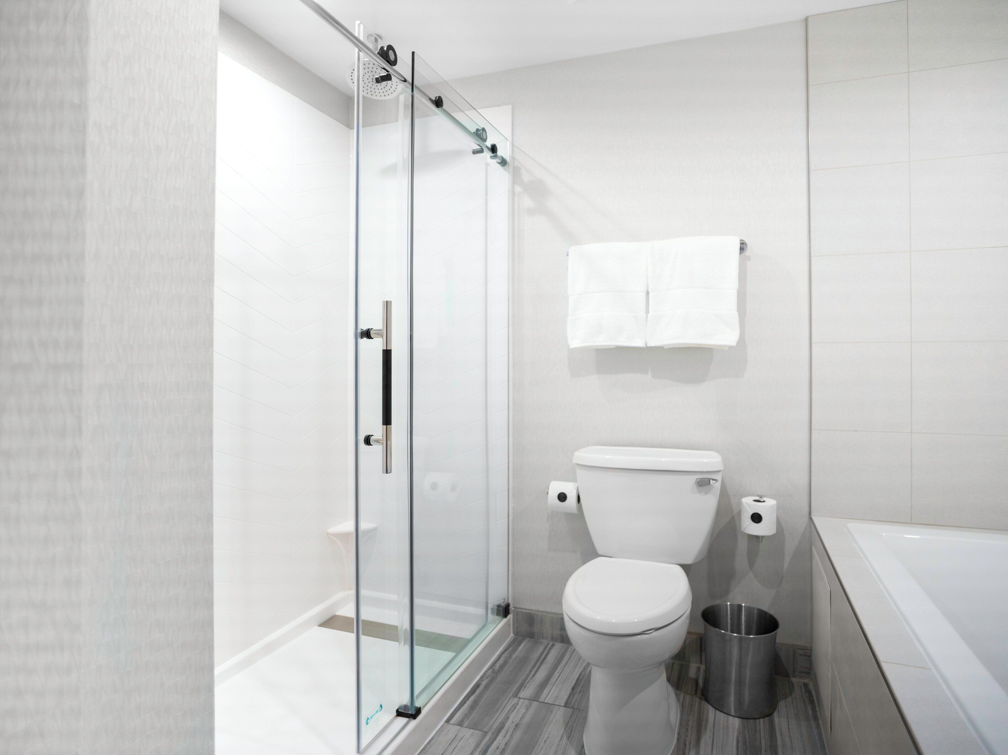 Un baño moderno con cabina de ducha de vidrio, inodoro y bañera.