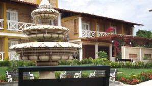 Une fontaine à plusieurs niveaux se trouve devant un bâtiment sur lequel est apposée une enseigne indiquant « Hôtel Porto Belo ».