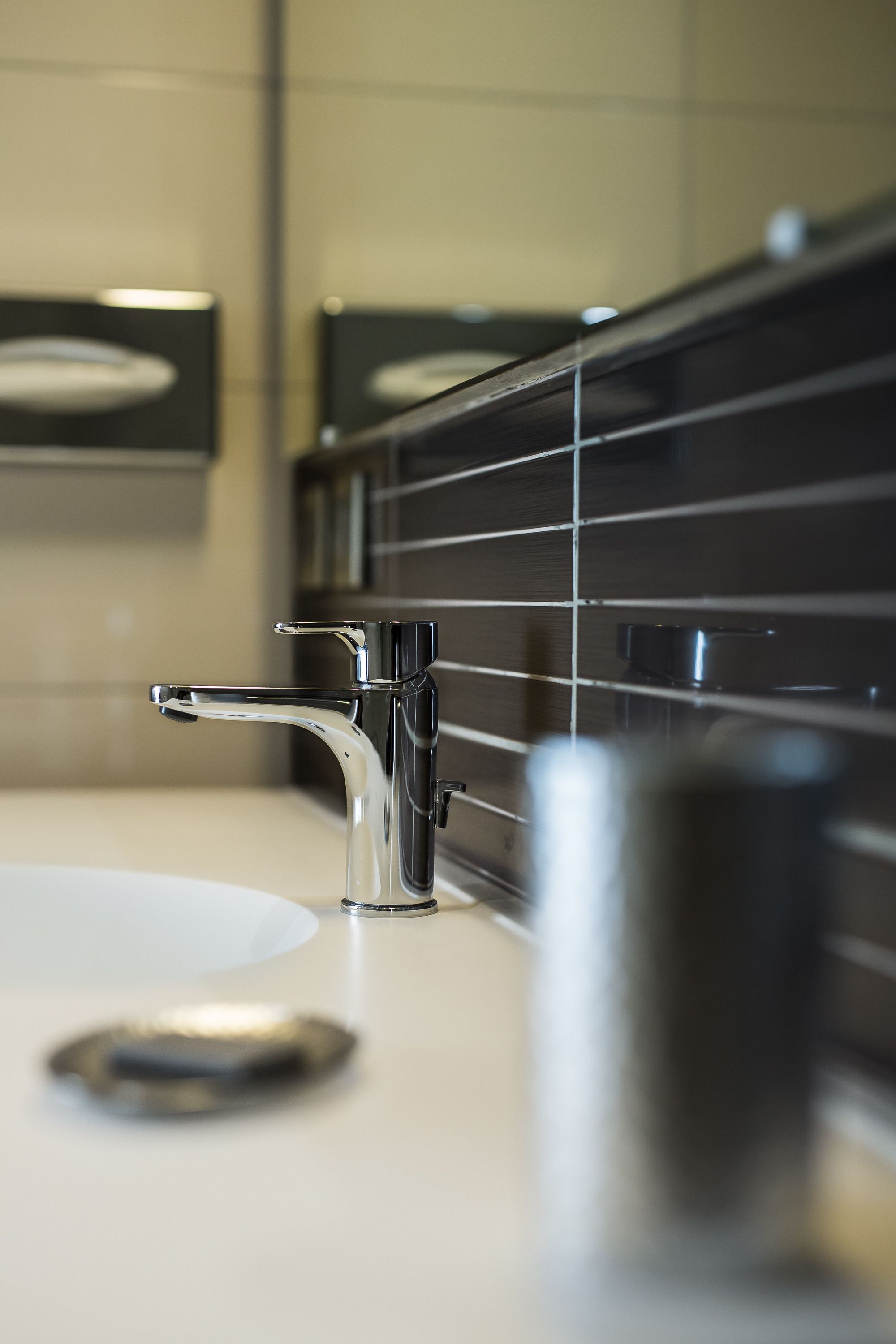 Un baño moderno con grifo cromado, lavamanos blanco y espejo.