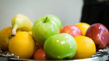 Un frutero con manzanas, naranjas y limones.