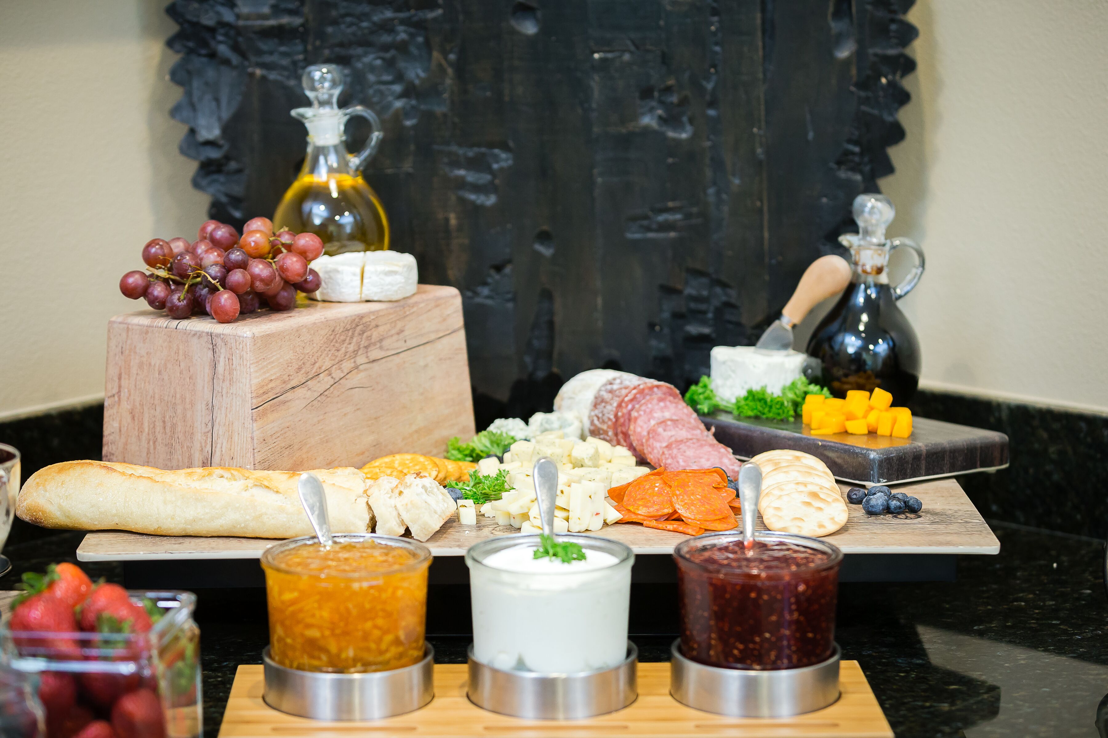 A charcuterie board with various cheeses, meats, and fruits.