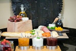 A charcuterie board with various cheeses, meats, and fruits.
