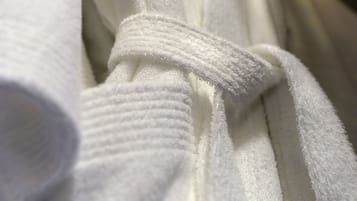 A white towel with a knot tied in the middle, hanging on a rack.