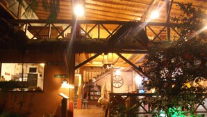 A reception area with a wooden ceiling, a reception desk, and a staircase leading to upper floors. - Hotel Hosteria Nantu (Puerto Lopez)