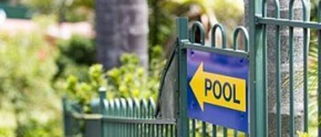 A sign indicating the direction to a pool.