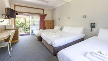 Una habitación de hotel con dos camas, un escritorio, un televisor y un teléfono.