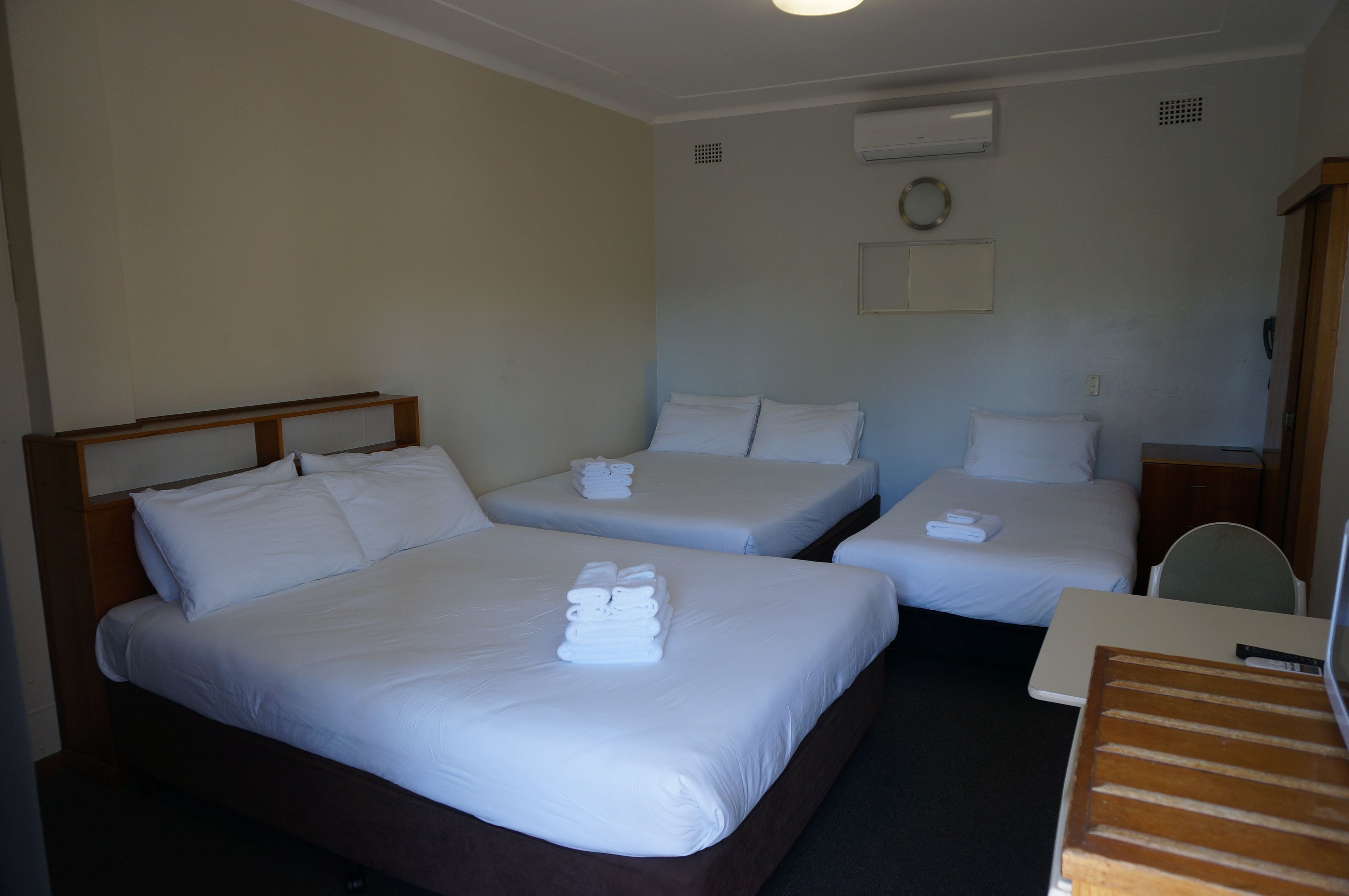 Een hotelkamer met twee eenpersoonsbedden en een bureau.