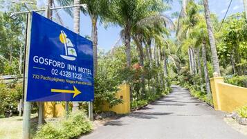 A sign for Gosford Inn Motel with directional arrow, located at 733 Pacific Highway, Niagara Park NSW 2250.