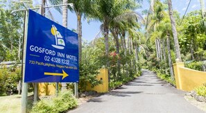 A sign for Gosford Inn Motel with directional arrow, located at 733 Pacific Highway, Niagara Park NSW 2250.