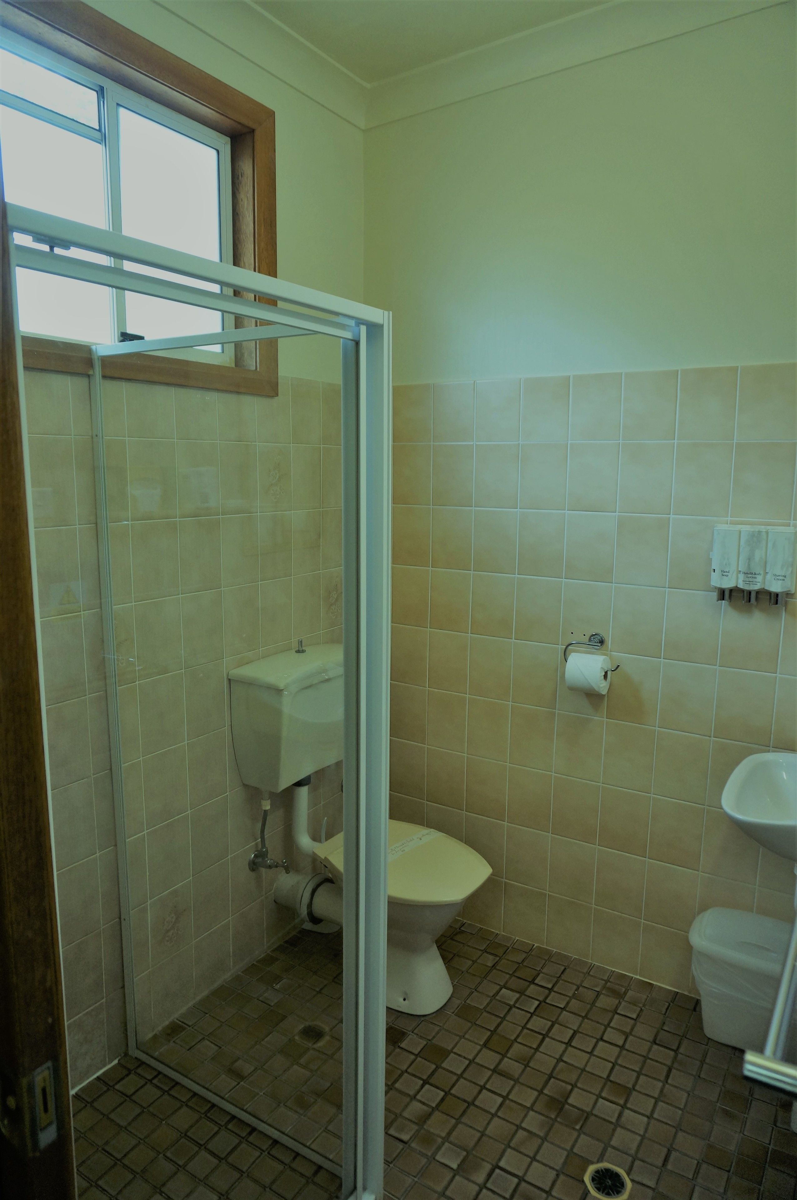 A small bathroom with a toilet, sink, and shower stall.