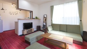 Ett modernt vardagsrum med en soffa, ett soffbord, en platt-TV och en öppen spis.