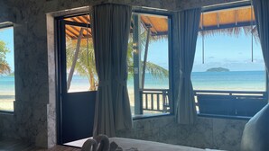 A bedroom with a bed, a view of the beach, and a thatched roof structure. - Kaibae Beach Resort (Ko Chang)