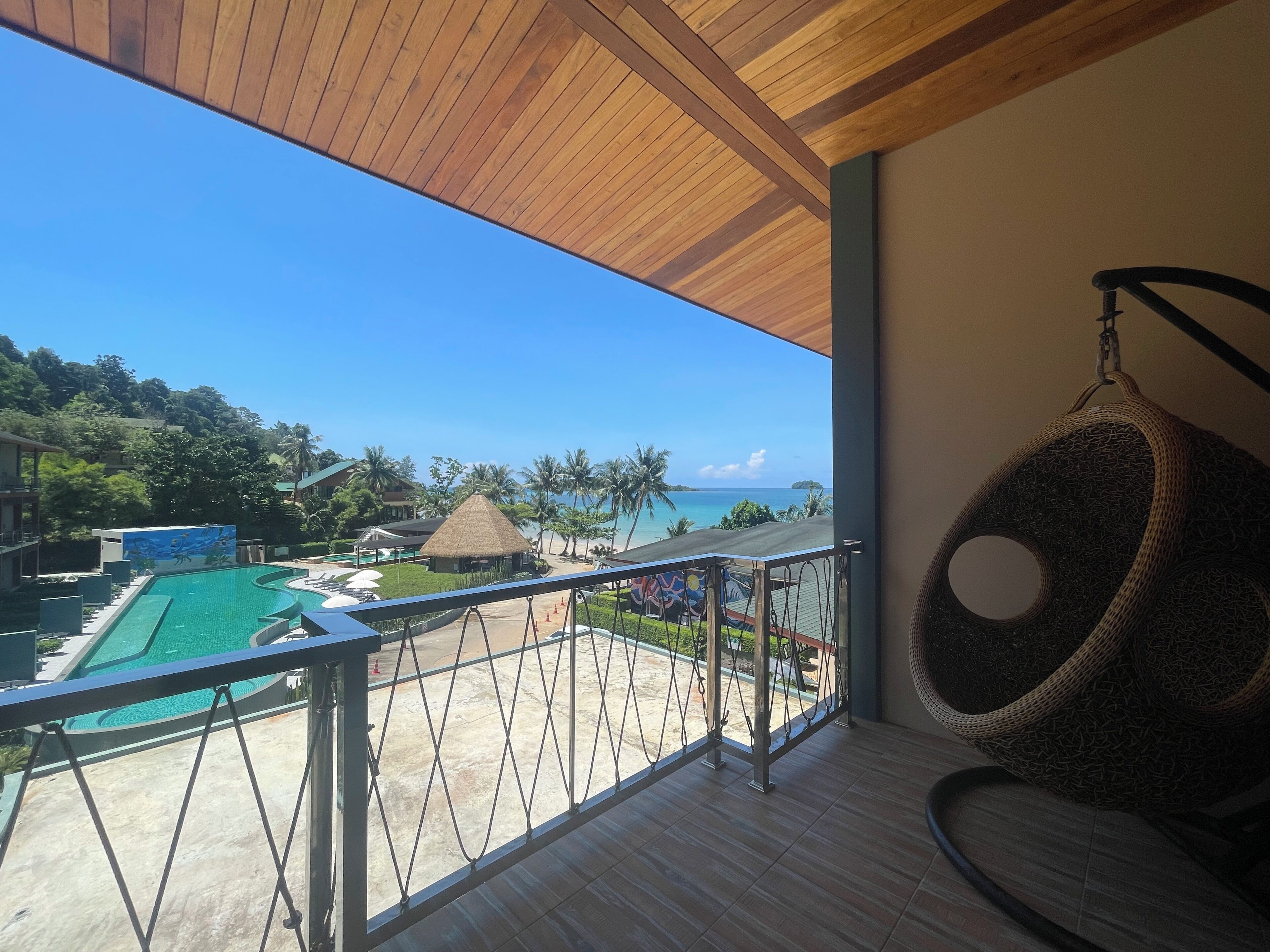 Un balcón con vistas a una piscina y a la playa.