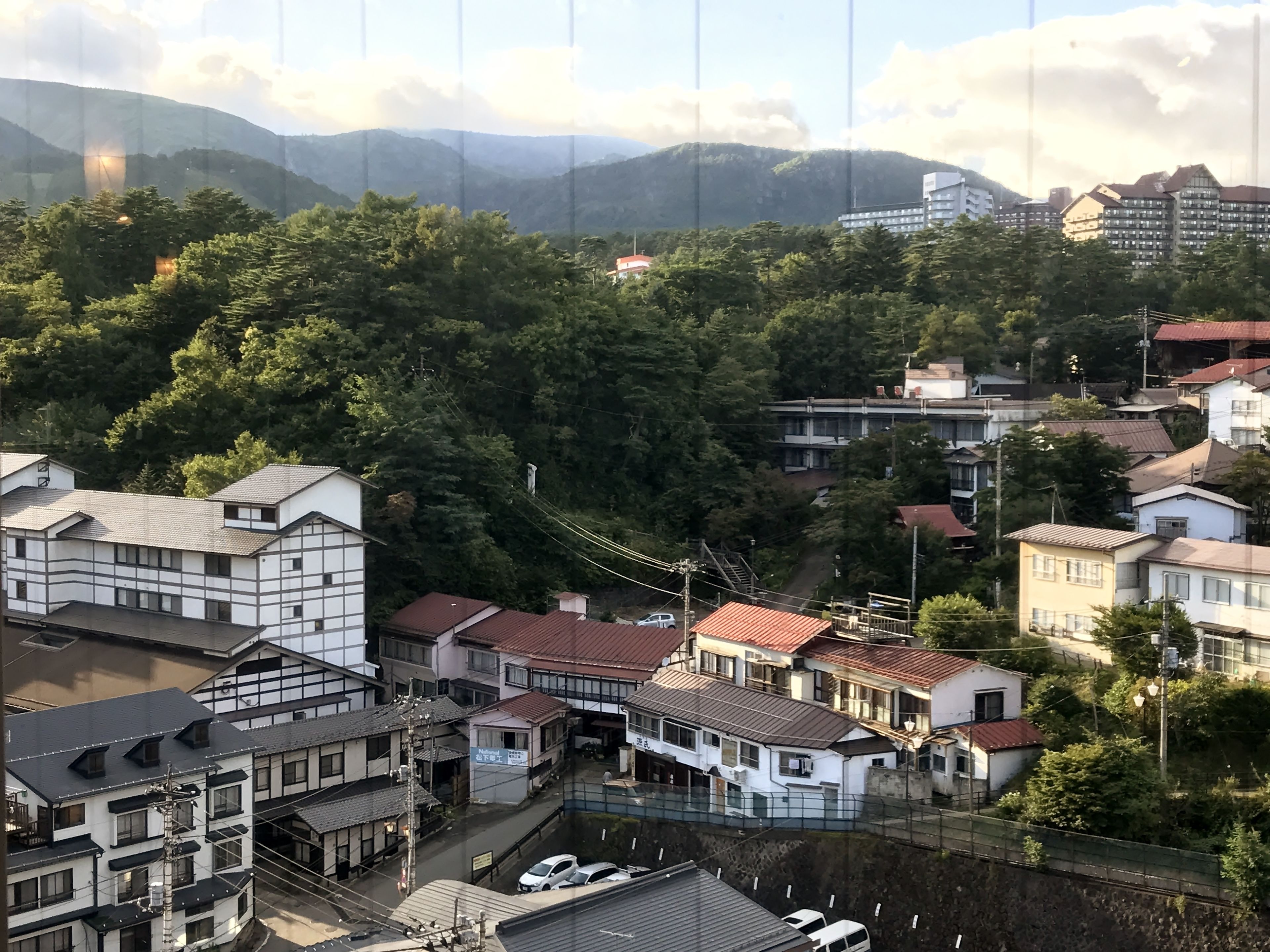 Ein Wohngebiet mit traditioneller japanischer Architektur, darunter Gebäude mit Ziegeldächern und Holzfassaden.