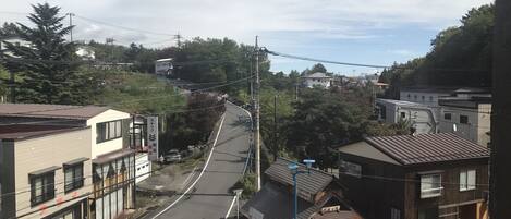 A street view with buildings, a road, and pedestrians.