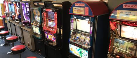 A row of slot machines with red stools in front.