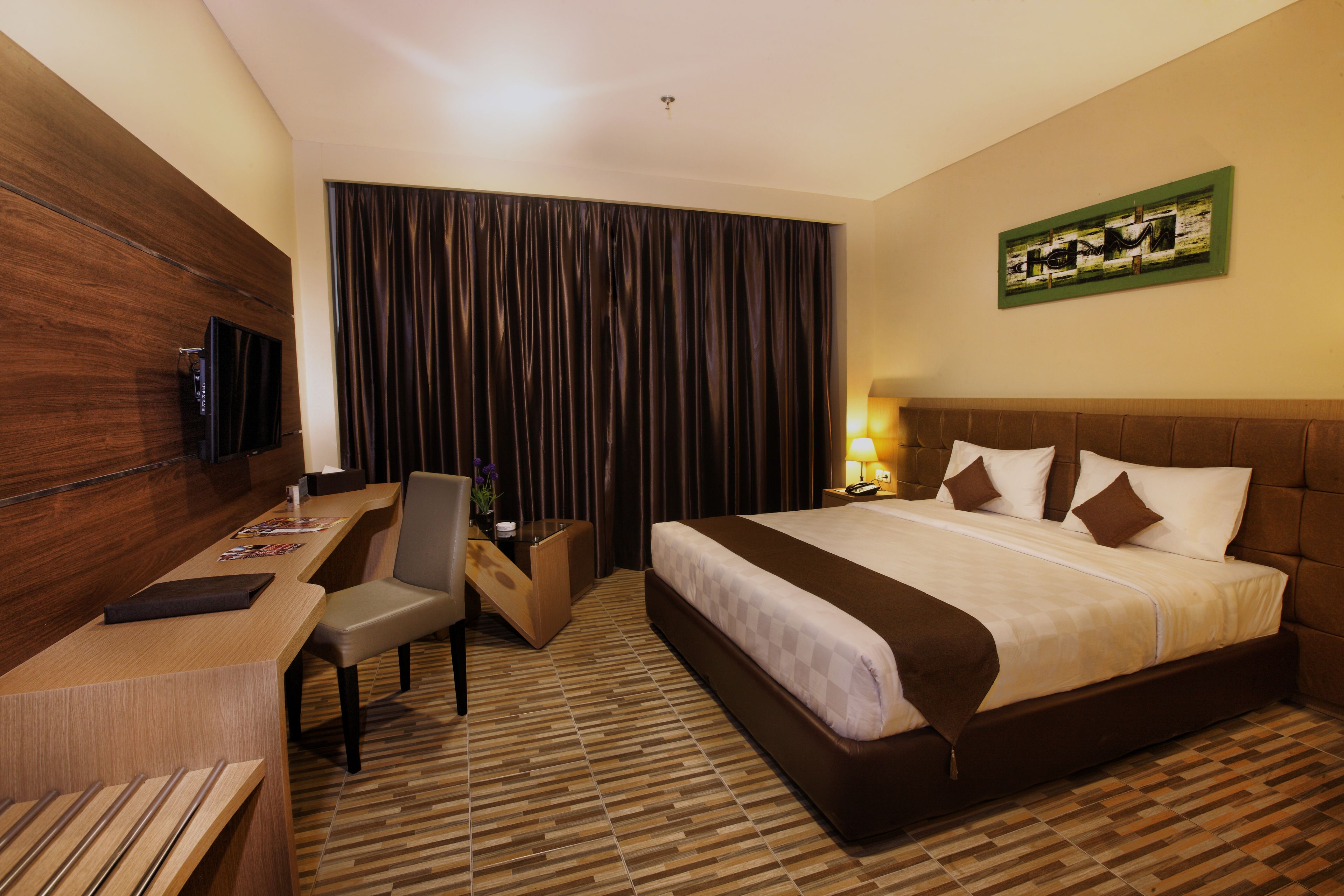 Une chambre d’hôtel équipée d’un lit, d’un bureau, d’une chaise et d’un téléviseur.
