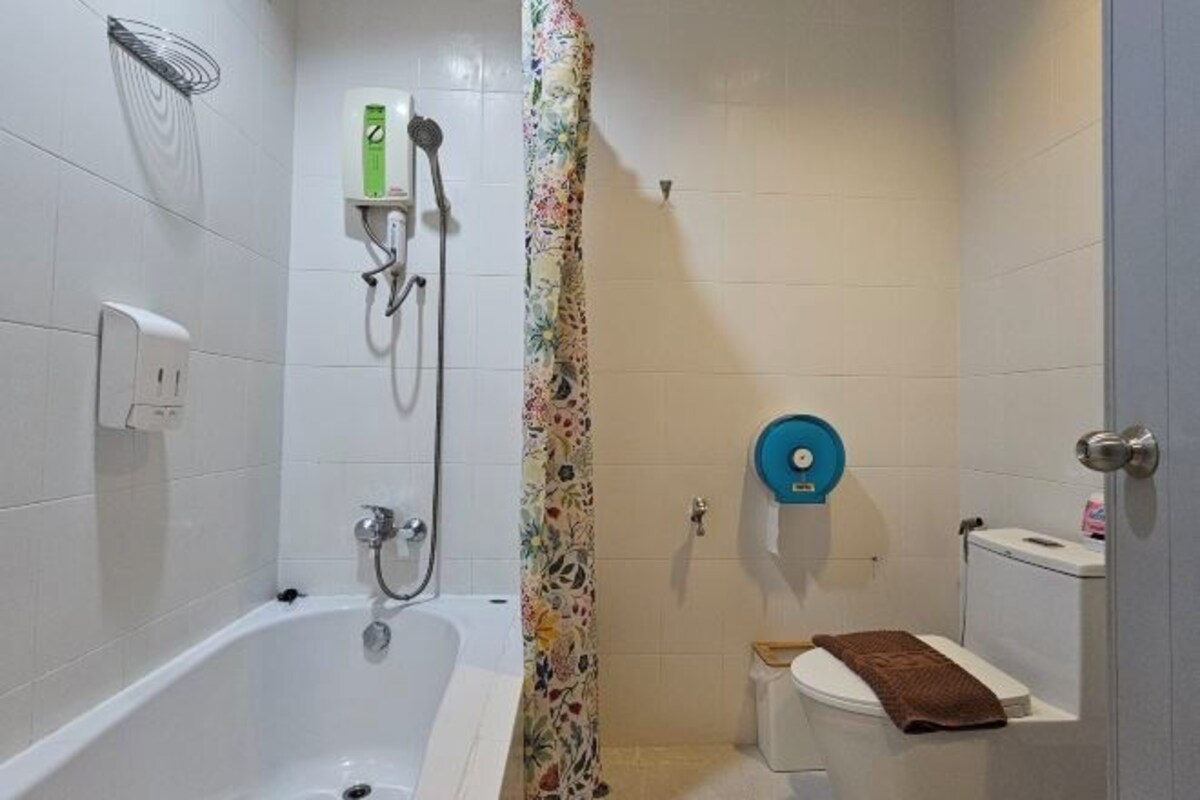 A bathroom with a bathtub, a shower, a toilet, and a towel rack.