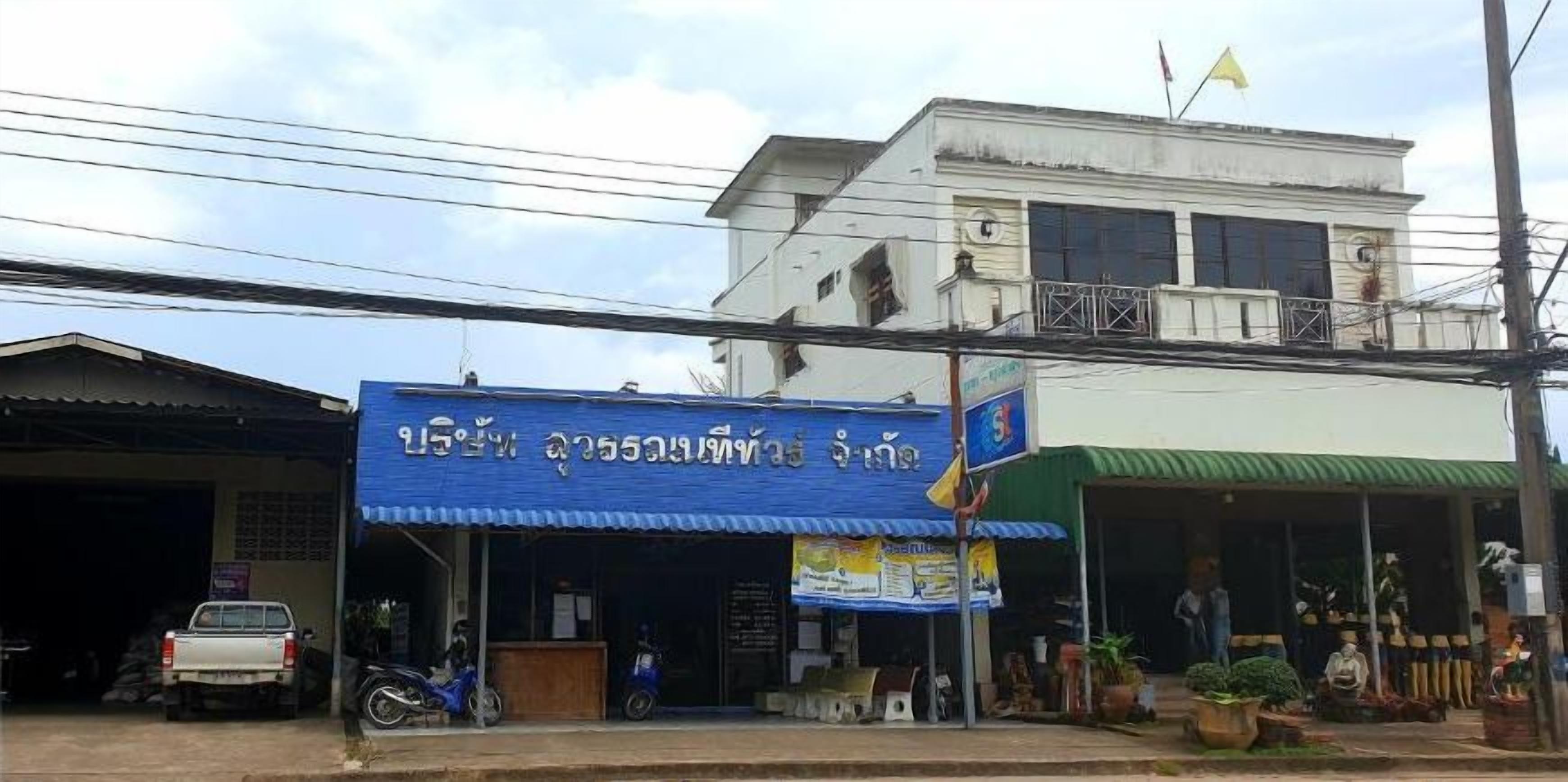 A commercial building with a blue storefront and a green awning.