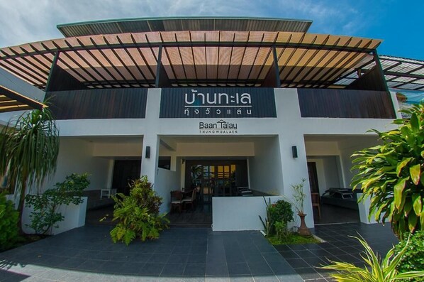 A modern building with a covered entrance and a sign reading "Baan Talay THUNGWULAEN".