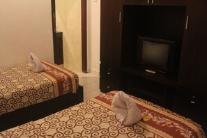 Two beds with patterned bedding and towels placed on them. - Letos Kubu Homestay (Kuta)