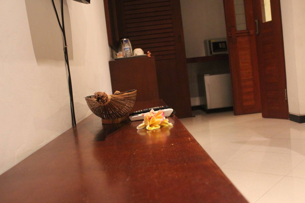 A wooden reception desk with a basket and a remote control.