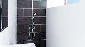 Une salle de bain moderne avec une douche, un lavabo et un miroir.