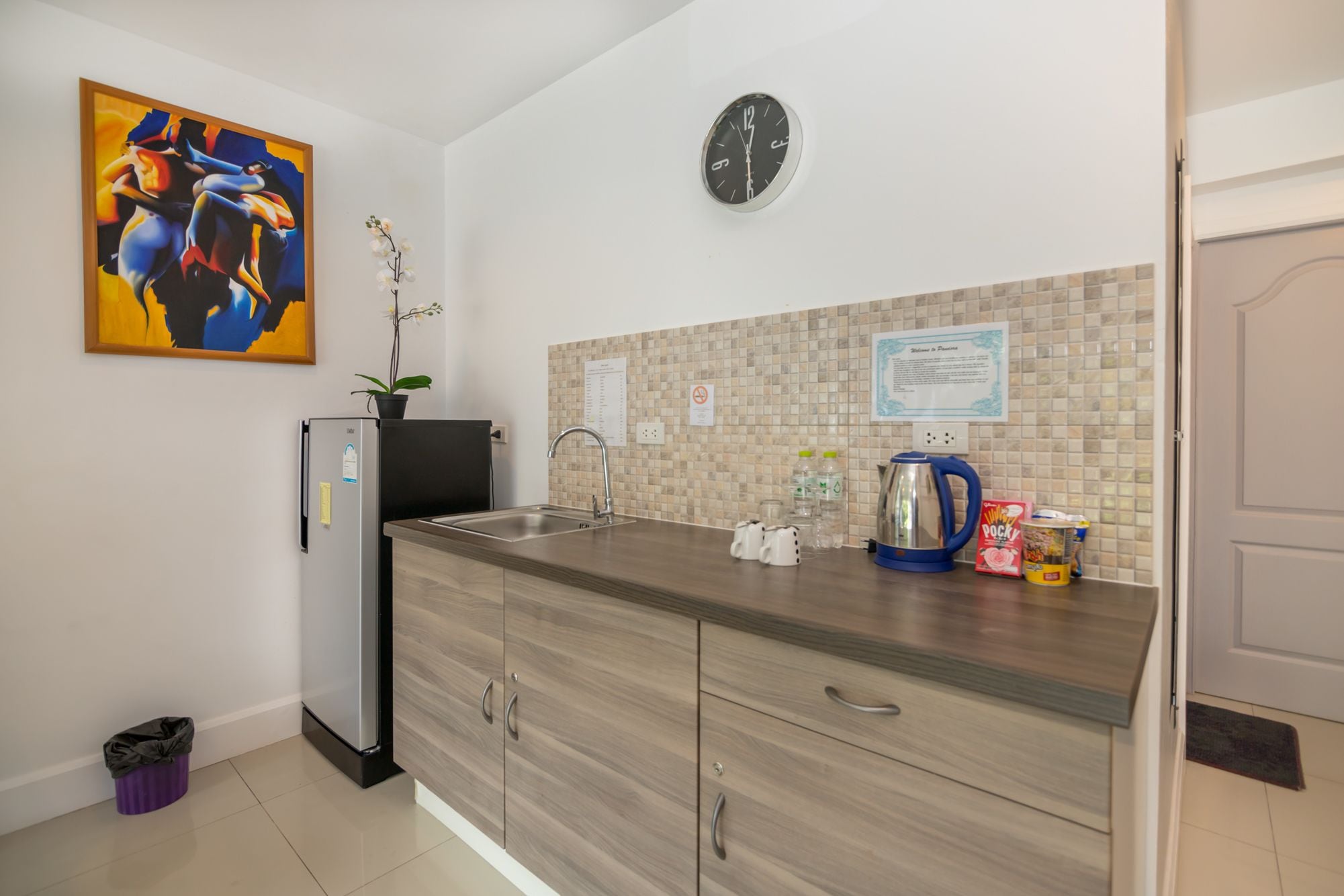 A modern kitchen with a wooden countertop, stainless steel appliances, and a tiled backsplash.