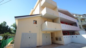 A multi-story residential building with a flat roof, balconies, and a gated entrance. - Moon River (Pescara)