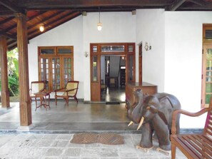 A reception area with a wooden elephant sculpture, a reception desk, and a seating area with chairs. - Lanrich Villa (Mirissa)