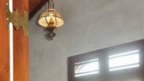 Un lit en bois dans une pièce dotée d’une grande fenêtre et d’un luminaire suspendu.