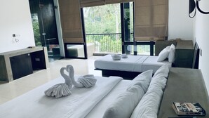 A hotel room with two beds, a sofa, a desk, and a view of the outdoors. - Handagedara Resort (Mirissa)