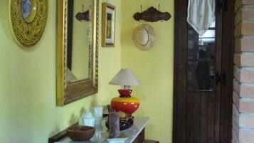 Una habitación con una mesa de madera, sillas, un espejo y una puerta.
