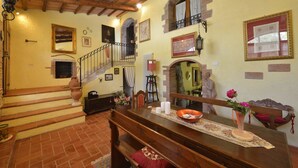 A dining area with a wooden table, benches, and a vase with flowers. - La Murata (Rapolano Terme)
