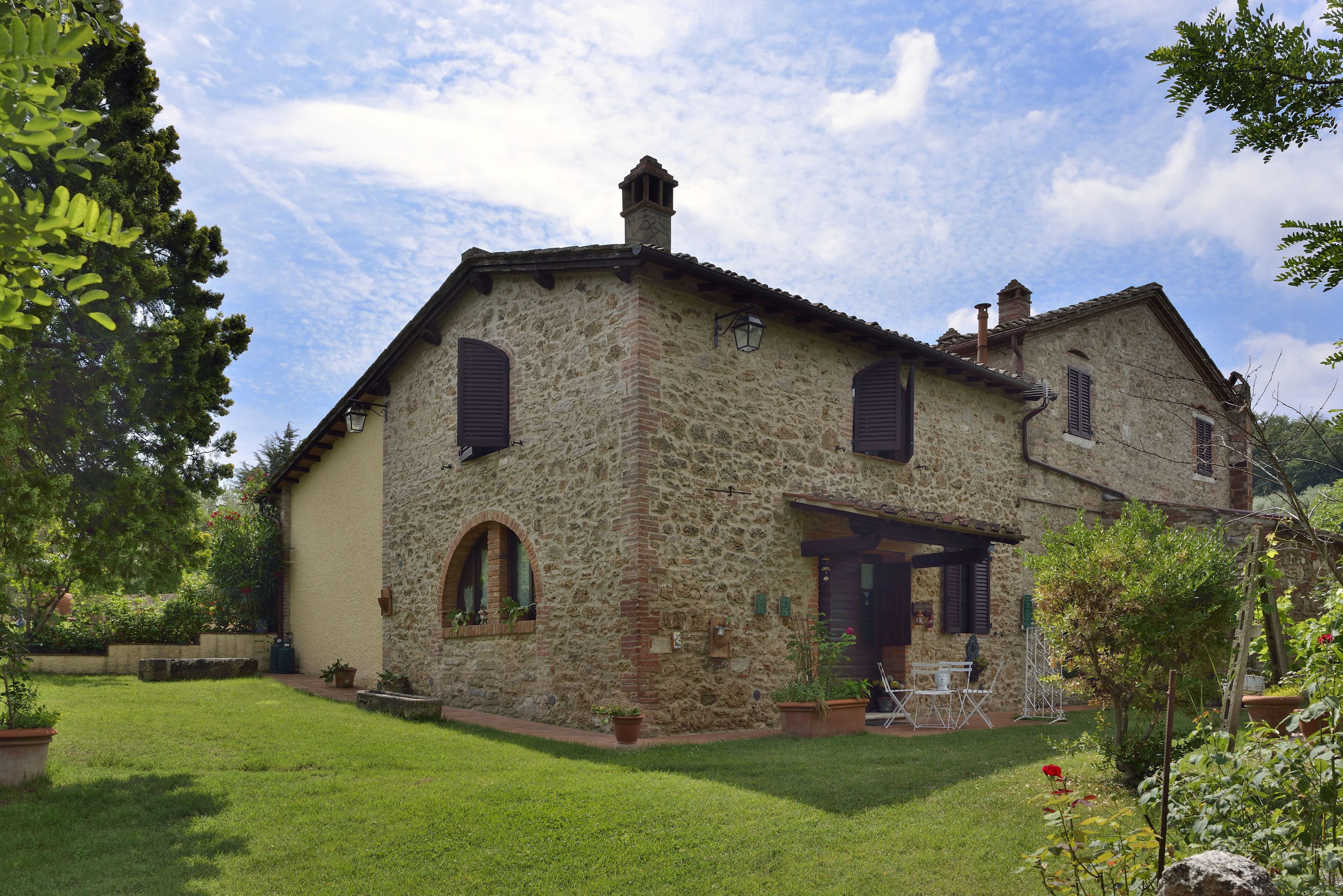 A stone house with a small garden and a patio.