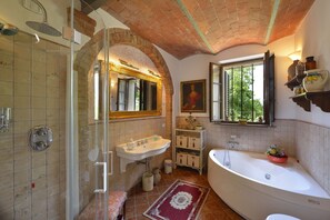 A bathroom with a shower, sink, and bathtub, featuring a brick ceiling and tiled walls. - La Murata (Rapolano Terme)