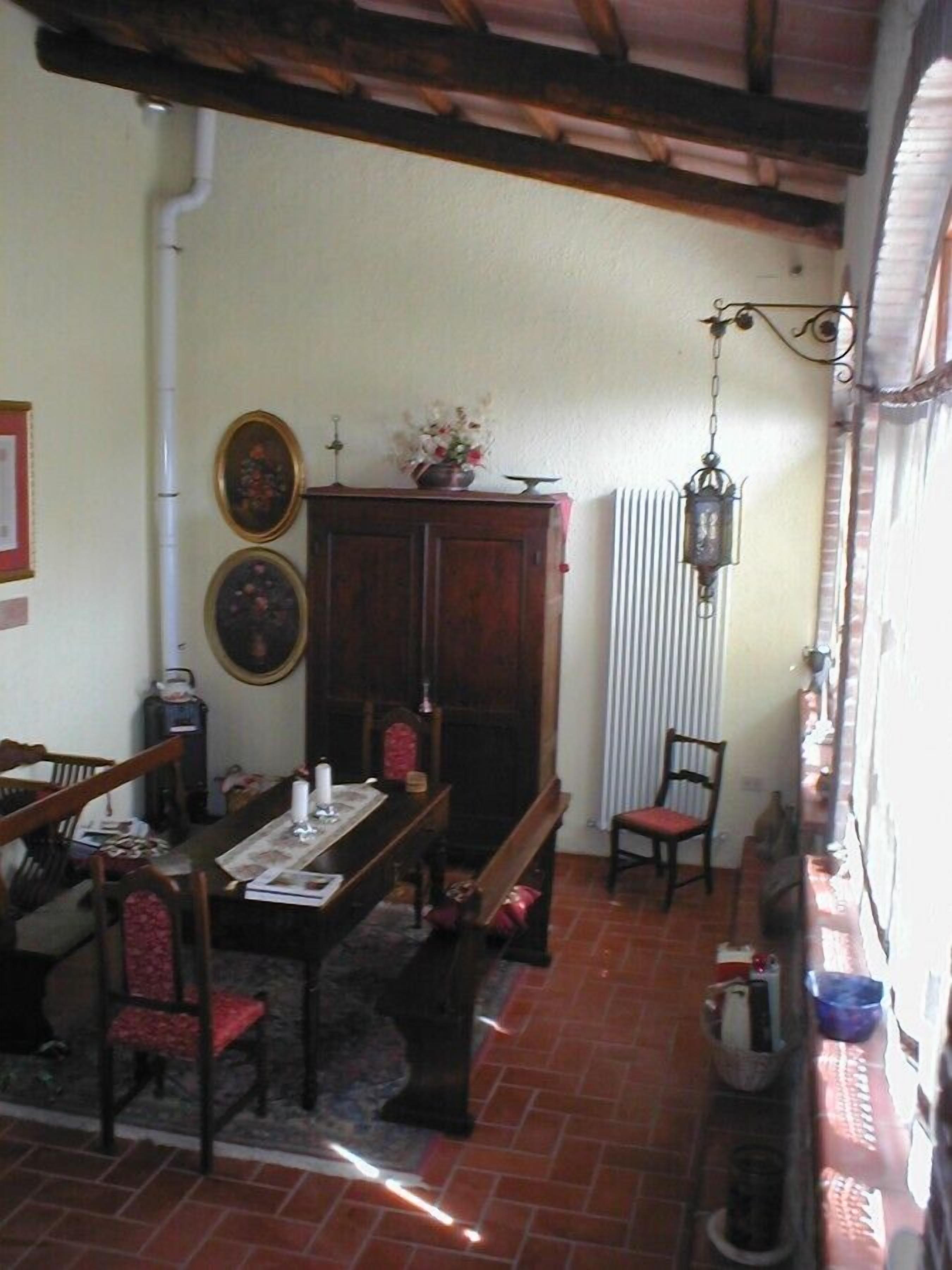A dining area with a wooden table, chairs, a cabinet, and a hanging lantern.