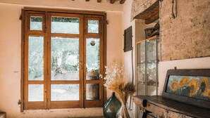 A room with a large wooden door, a rustic wooden bench, and a vase with dried plants. - Agriturismo La Torretta (Siena)