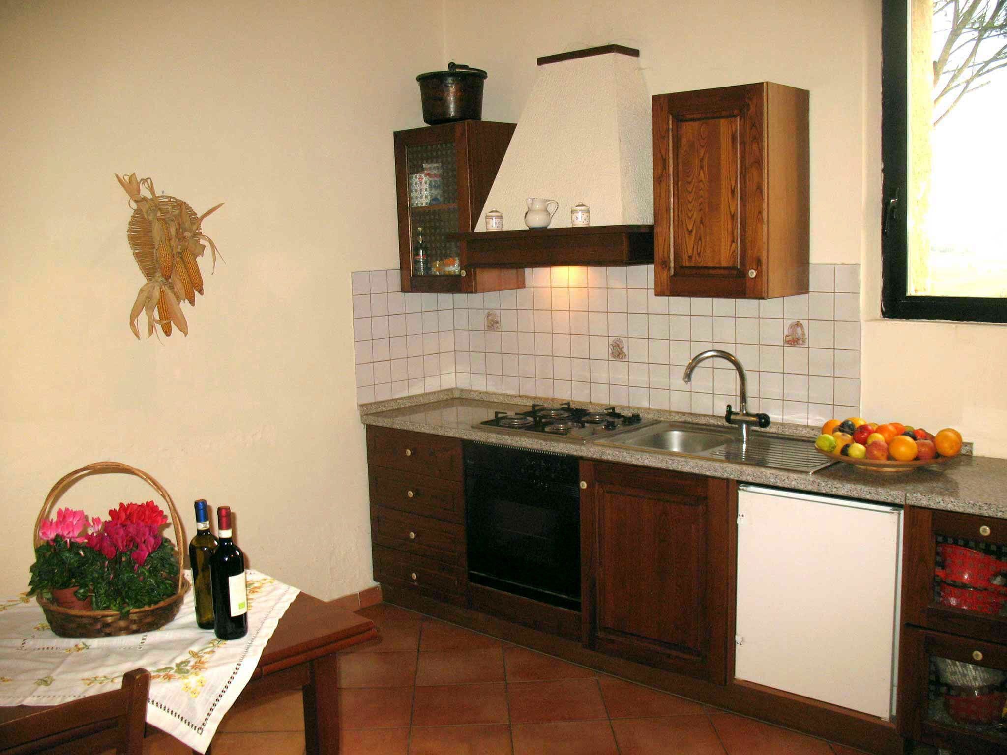 A compact kitchen with a gas stove, sink, and wooden cabinets.