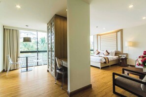 Habitación de hotel con cama, escritorio, silla y vista al exterior.