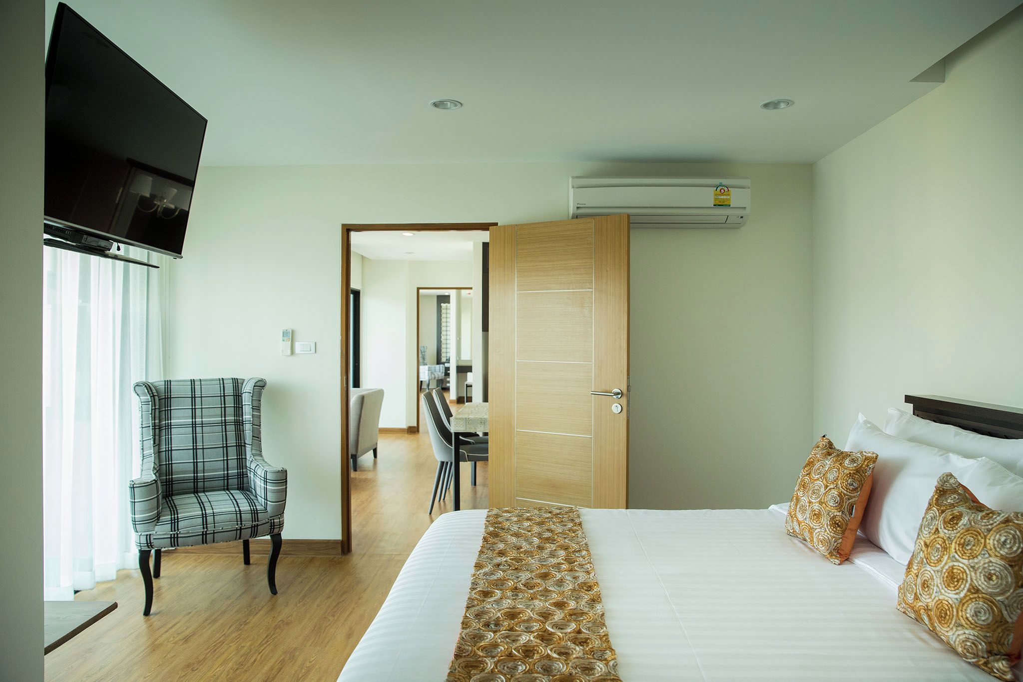 Una habitación de hotel con una cama, televisión, silla y escritorio.