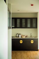 Una cocina moderna con armarios oscuros, un lavamanos de acero inoxidable y suelo de madera.