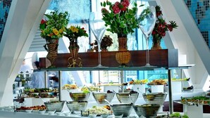 A buffet setup with various food items and decorative vases. - Vikingen Infinity Resort & Spa - All Inclusive (Alanya)